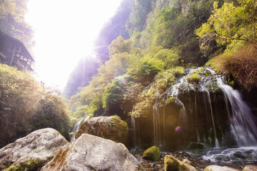 Idyllischer Blick auf einen Wasserfall in den Bergen an einem sonnigen Tag - CAVF28072