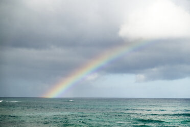 Idyllischer Blick auf einen Regenbogen über dem Meer bei bewölktem Himmel - CAVF28107