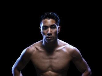 Portrait of confident kickboxer against black background - CAVF28148