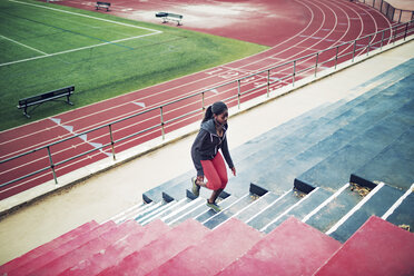 High angle view of sportswoman running on steps at stadium - CAVF28176