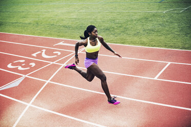 Female track and field athletes running on sunny track - Stock Image -  F034/0733 - Science Photo Library