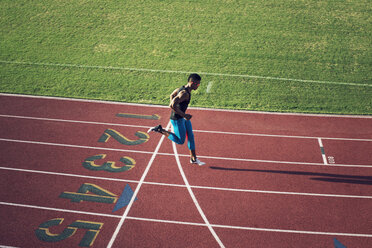 High angle view of male athlete crossing finish line on field - CAVF28275