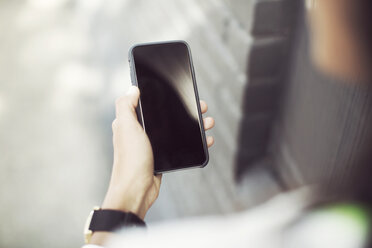 Cropped image of woman holding smartphone - CAVF28281