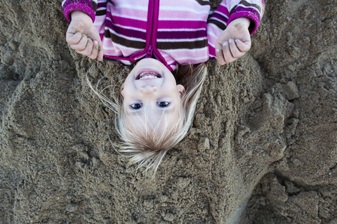 Overhead-Porträt eines Mädchens am Sandstrand, lizenzfreies Stockfoto