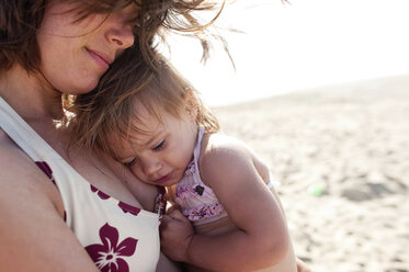 Nahaufnahme einer Mutter mit einem Mädchen am Strand an einem sonnigen Tag - CAVF28335