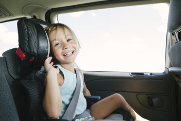 Portrait of smiling girl sitting in car - CAVF28347