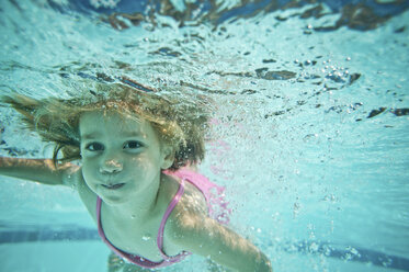 Porträt eines Mädchens, das unter Wasser im Pool schwimmt - CAVF28356