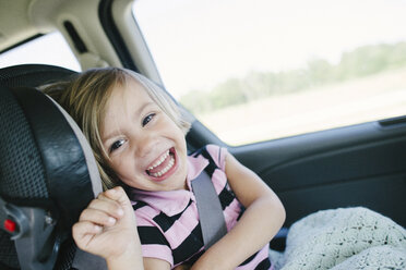Porträt eines fröhlichen Mädchens, das im Auto sitzt - CAVF28369