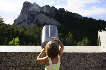 Rear view of girl looking through telescope at Mount Rushmore National Memorial - CAVF28371