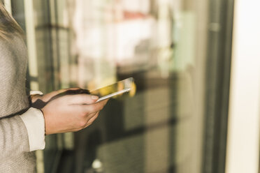 Close-up of businesswoman holding cell phone - UUF13130