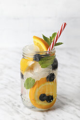 Glass of infused water with orange, blueberries and mint on ice - RTBF01100