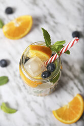 Glass of infused water with orange, blueberries and mint on ice - RTBF01101