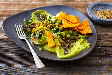 Guacamole with grilled green tomatoes, cucumber and tortilla chips stock photo