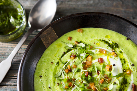 Cream of avocado soup with bacon and mint pesto stock photo