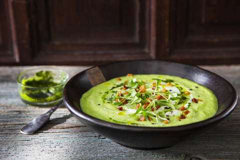 Cream of avocado soup with bacon and mint pesto stock photo