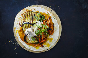 Pulled Chicken Wrap, carrot, grilled aubergine, curry hummus and herbs on chopping board - KSWF01866