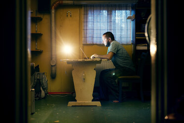 Man sitting at table and using laptop - FOLF00054