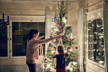 Mutter mit Tochter beim Schmücken des Weihnachtsbaums - FOLF00057