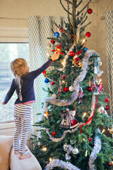 Mädchen schmückt Weihnachtsbaum - FOLF00058