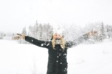 Smiling woman with falling snow in foreground - FOLF00113