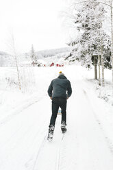 Mann geht entlang einer verschneiten Straße - FOLF00114