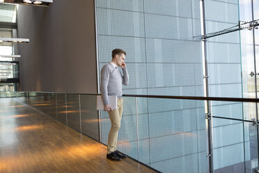 Young businessman talking on phone in office building - FOLF00130