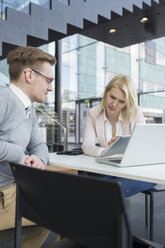 Kollegen sitzen am Schreibtisch und benutzen ein digitales Tablet - FOLF00139