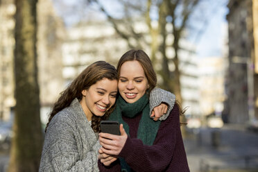 Two teenage girls taking a selfie in the city - FMKF04975