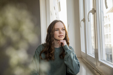 Teenager-Mädchen, das aus dem Fenster schaut und träumt - FMKF04983