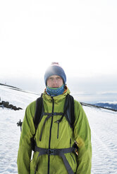 Porträt eines Mannes auf einem schneebedeckten Feld vor dem Himmel - CAVF28381