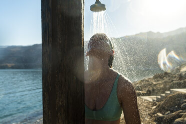 Frau duscht im Stehen gegen den Himmel - CAVF28407