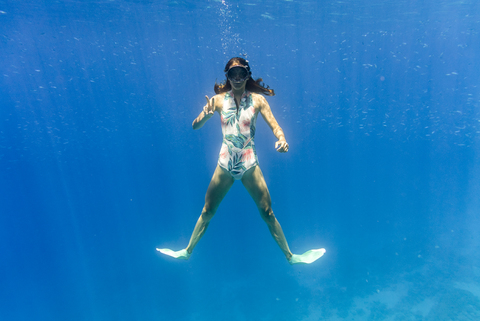 Porträt einer Frau, die beim Schwimmen im Meer gestikuliert, lizenzfreies Stockfoto