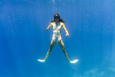 Porträt einer Frau, die beim Schwimmen im Meer gestikuliert - CAVF28412