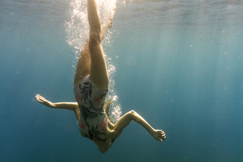 Woman swimming upside down in sea - CAVF28415