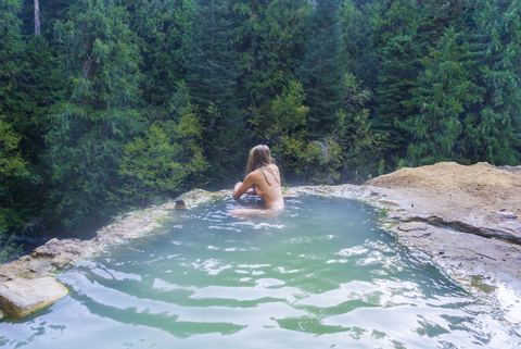 Frau schwimmt in heißer Quelle im Wald, lizenzfreies Stockfoto