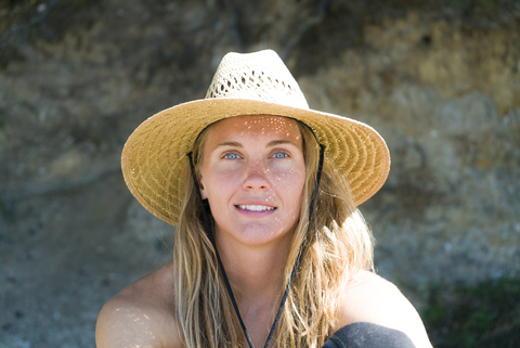 Close-up-Porträt einer Frau mit Sonnenhut am Strand, lizenzfreies Stockfoto