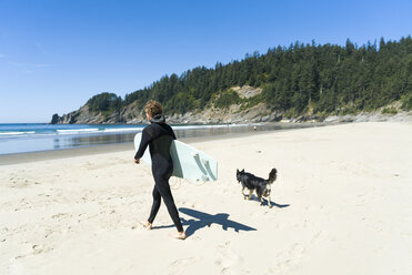 Mann mit Surfbrett und Hund am Strand - CAVF28452