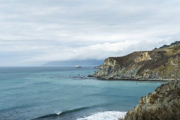 Scenic view of sea by mountains against cloudy sky - CAVF28469