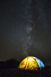 Illuminated tent on field against star field - CAVF28473