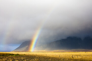 Majestätischer Blick auf einen Regenbogen über der Landschaft inmitten eines bewölkten Himmels - CAVF28482