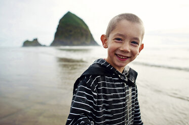 Portrait of happy boy standing at beach against sky - CAVF28498