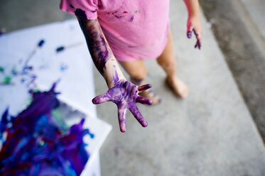 Low section of girl with messy hand standing on floor at home - CAVF28505