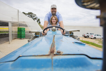 Farmer showing his daughter, how to drive a tractor - ZEF15227