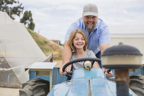 Landwirt zeigt seiner Tochter, wie man einen Traktor fährt - ZEF15228