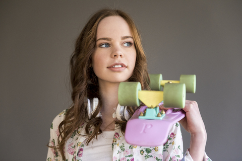 Porträt eines Teenagers mit rosa Skateboard, lizenzfreies Stockfoto