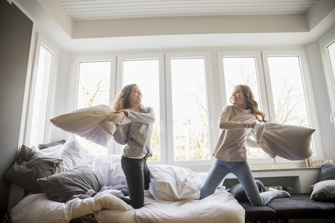 Kissenschlacht zwischen zwei besten Freunden zu Hause, lizenzfreies Stockfoto