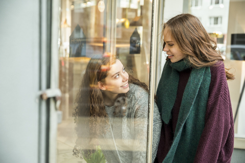 Two teenage girls at shop window stock photo