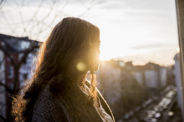 Teenage girl on balcony at evening twilight - FMKF05005