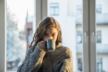 Portrait of teenage girl drinking coffee at home - FMKF05006