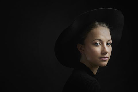 Porträt einer jungen Frau vor schwarzem Hintergrund, lizenzfreies Stockfoto